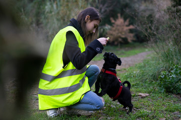 Volunteer from an animal shelter giving a dog treat to an abandoned dog.