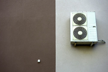 Air conditioner attached to the insulated wall of the building