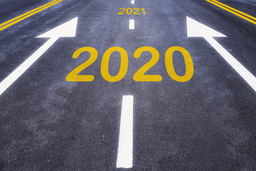 Number of 2020 to 2021 on asphalt road surface with marking lines, happy new year concept