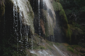 Water falling in small waterfall with green moss