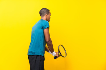 Afro American tennis player man over isolated yellow background
