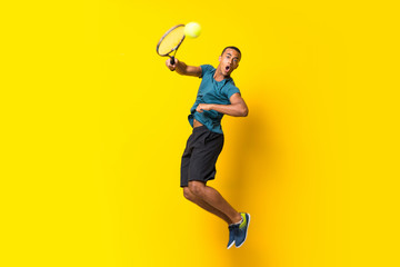 Fototapeta na wymiar Afro American tennis player man over isolated yellow background