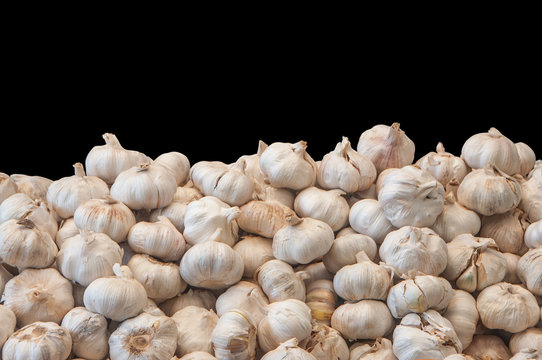 White garlic pile texture isolated on black background