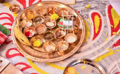Bengali marriage rituals with beautiful decoration of multiple ingredient in brass bowls on a brass plate for bride and groom in India