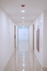 Corridor of modern condominium with fire extinguisher placed, smoke detector, alarm and fire exit...