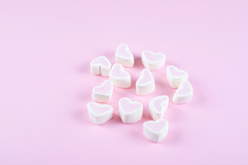 Pink marshmallows shaped heart on pink background. Valentines day concept