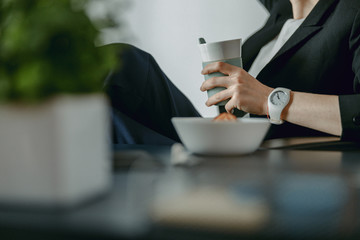 Cropped photo of female hands holding coffee