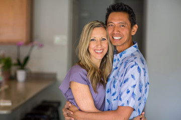 Portrait of a mixed race couple smiling and hugging.