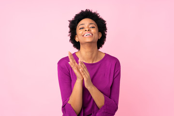 African american woman over isolated pink background applauding after presentation in a conference