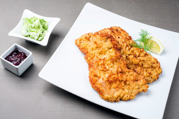 Traditionelles frittiertes Wiener Schnitzel von der Oberschale vom Kalb mit Gurken Salat und...