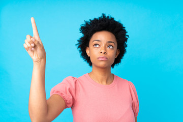 African american woman over isolated blue background touching on transparent screen