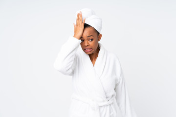 African american woman  in a bathrobe over isolated background having doubts with confuse face...