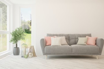 Stylish room in white color with sofa and summer landscape in window. Scandinavian interior design. 3D illustration