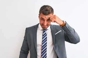 Young handsome business man wearing suit and tie over isolated background pointing unhappy to pimple on forehead, ugly infection of blackhead. Acne and skin problem