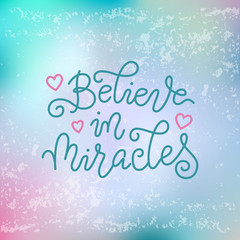 Naklejka na ściany i meble Modern calligraphy lettering of Believe in miracles in blue on blue pink textured background
