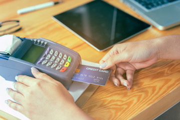 Asian girl hand hold card slip on credit card machine in supermarket shopping mall counter service for smart life, internet of things,smart pay, businesswomen online for business service concept