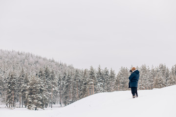 Photographer in winter frost covered forest