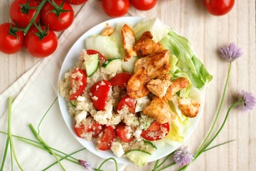 Quinoa salad with chicken fillets, lettuce, tomato, cucumber and chives