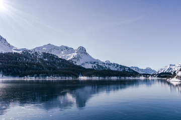 A frozen lake in the engadine, during a sunny winter day in the alps, near the village of Sankt...