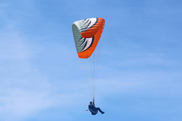 Paraglider flying wing in a blue sky