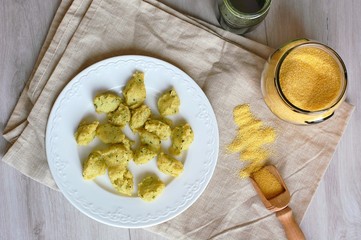 Corn flour polenta gnocchi with green peste on white plate