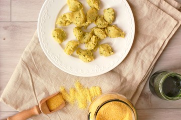 Corn flour polenta gnocchi with green peste on white plate