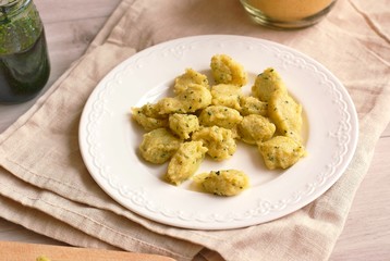 Corn flour polenta gnocchi with green peste on white plate