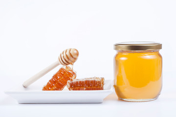 jar of honey and wooden spoon isolated on white