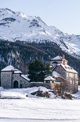 A castle in the snowy mountains during a sunny winter day in the alps, near the village of Sankt Moritz and Silvaplana, Switzerland - January 2020