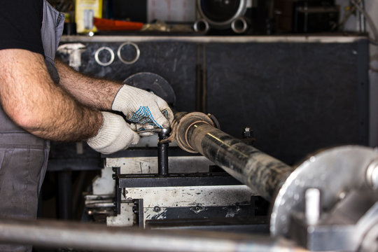 Worker repairs a car part in a workshop.