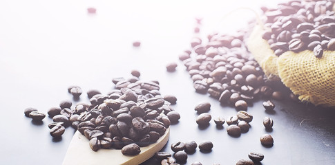 Coffee beans with green leaves for cooking. Bag of coffee. Coffee beans roasted on the table.
