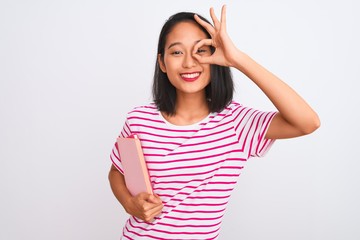 Obraz na płótnie Canvas Young beautiful chinese woman holding books standing over isolated white background with happy face smiling doing ok sign with hand on eye looking through fingers