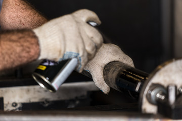 Worker repairs a car part in a workshop.