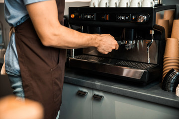 Close up of guy making coffee in coffee shop