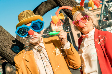 Elderly man holding bubbles on the street