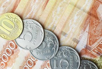 Russian banknotes and coins "rubles." Banknote with the inscription "five thousand rubles" and coins of 5 and 10 rubles. Background made of money.