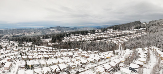 Aerial Panoramic View of a Residential Neighborhood with homes and trees covered in white after a big snow storm in the Lower Mainland. Taken in Coquitlam, Vancouver, BC, Canada.