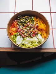 Poke bowl with tuna and vegetables on the white tile table