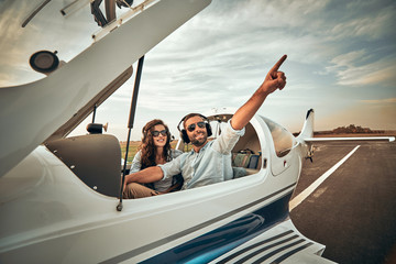 Just look there! Two pretty beautiful handsome carefree couple having free time in a small plane. © HBS