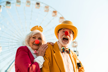 Cheerful mature couple having fun while walking in an amusement park