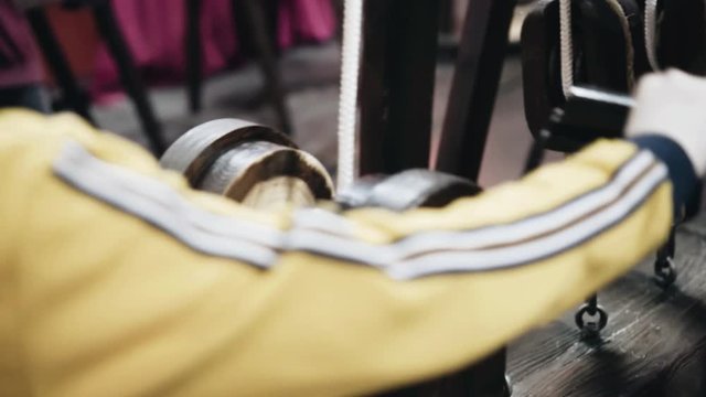 The boy controls the lift mechanism of da Vinci's invention. Close-up from behind the boy. Training and development.