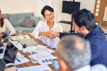 Group of business workers smiling happy and confident. Working together with smile on face shaking hands at the office