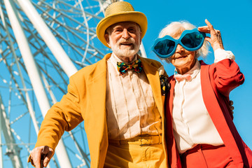 Happy cheerful elderly couple posing in colorful costumes