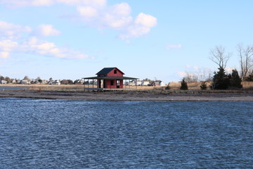 Obraz premium Old weathered red fishing shack on coastal New England pier beach 