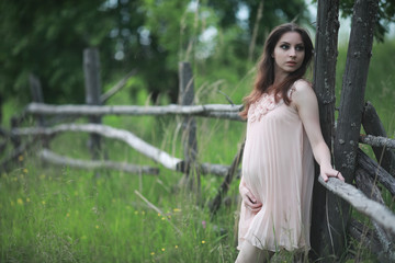 Naklejka premium Pregnant girl in a dress in nature