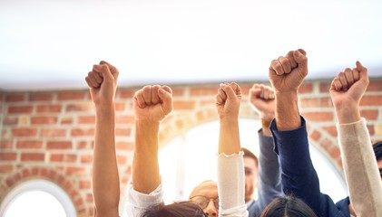 Group of business workers standing with fists up at the office