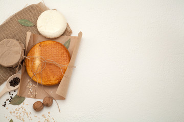 Smoked cheese, decorated with walnuts, isolated on a white background, there is a place for the inscription. The concept of cheese.