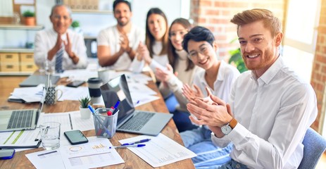 Group of business workers smiling happy and confident. Working together with smile on face looking at the camera applauding at the office
