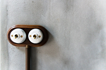 Two vintage light switches on a concrete wall 