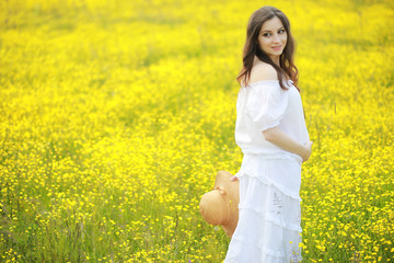 Fototapeta premium Pregnant woman in a dress in a field of flowers